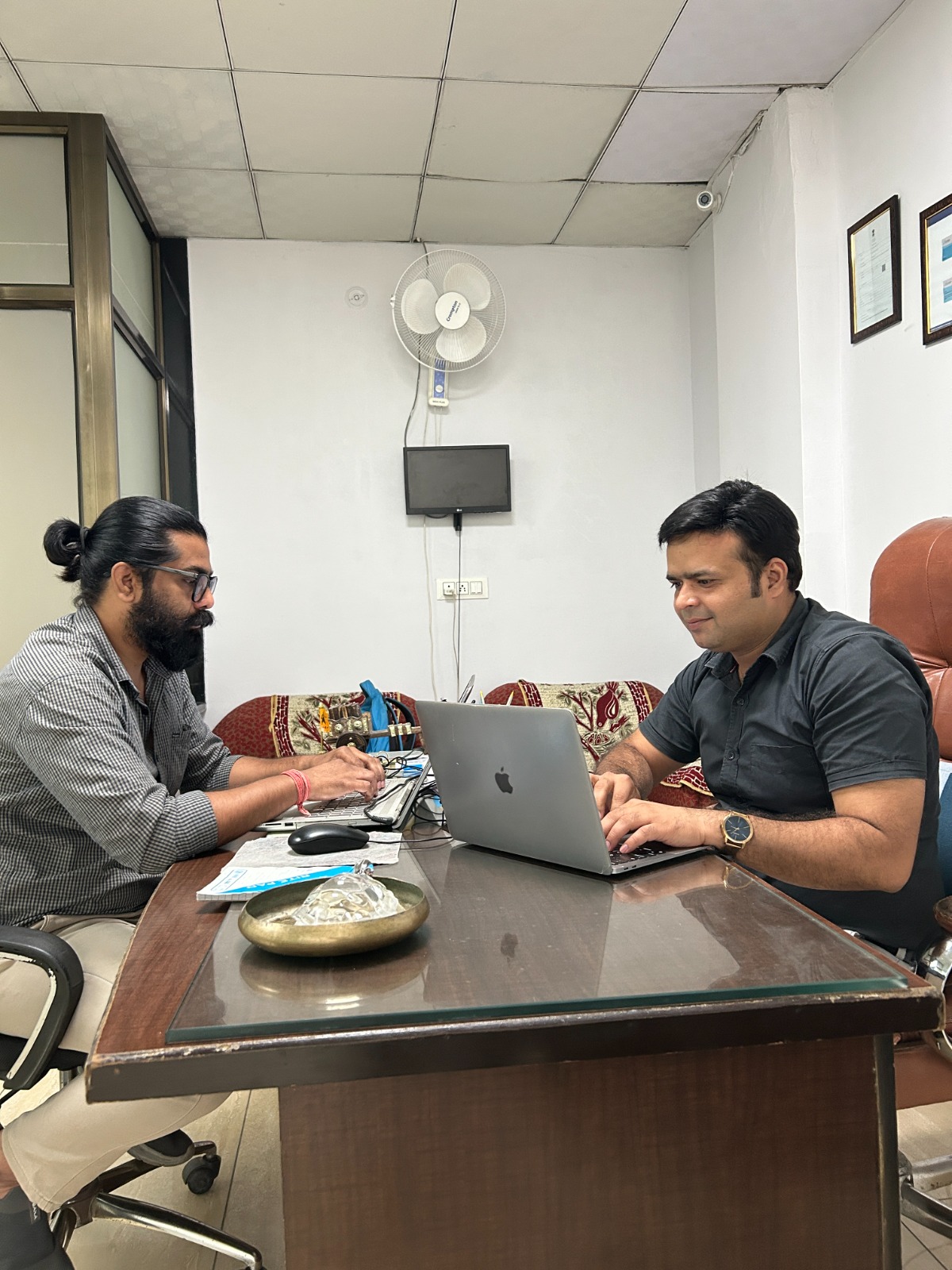 Founding team collaborating around a laptop in an early workspace
